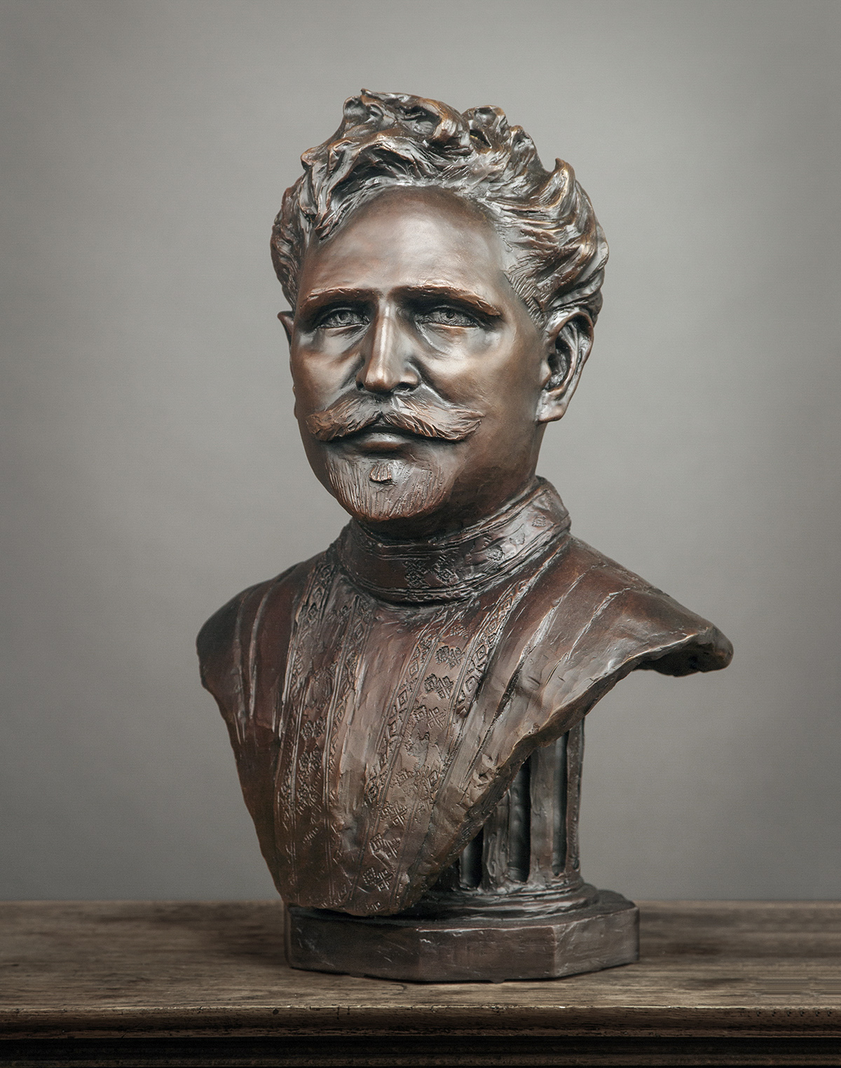 bronze bust figure of a man, looking at viewer